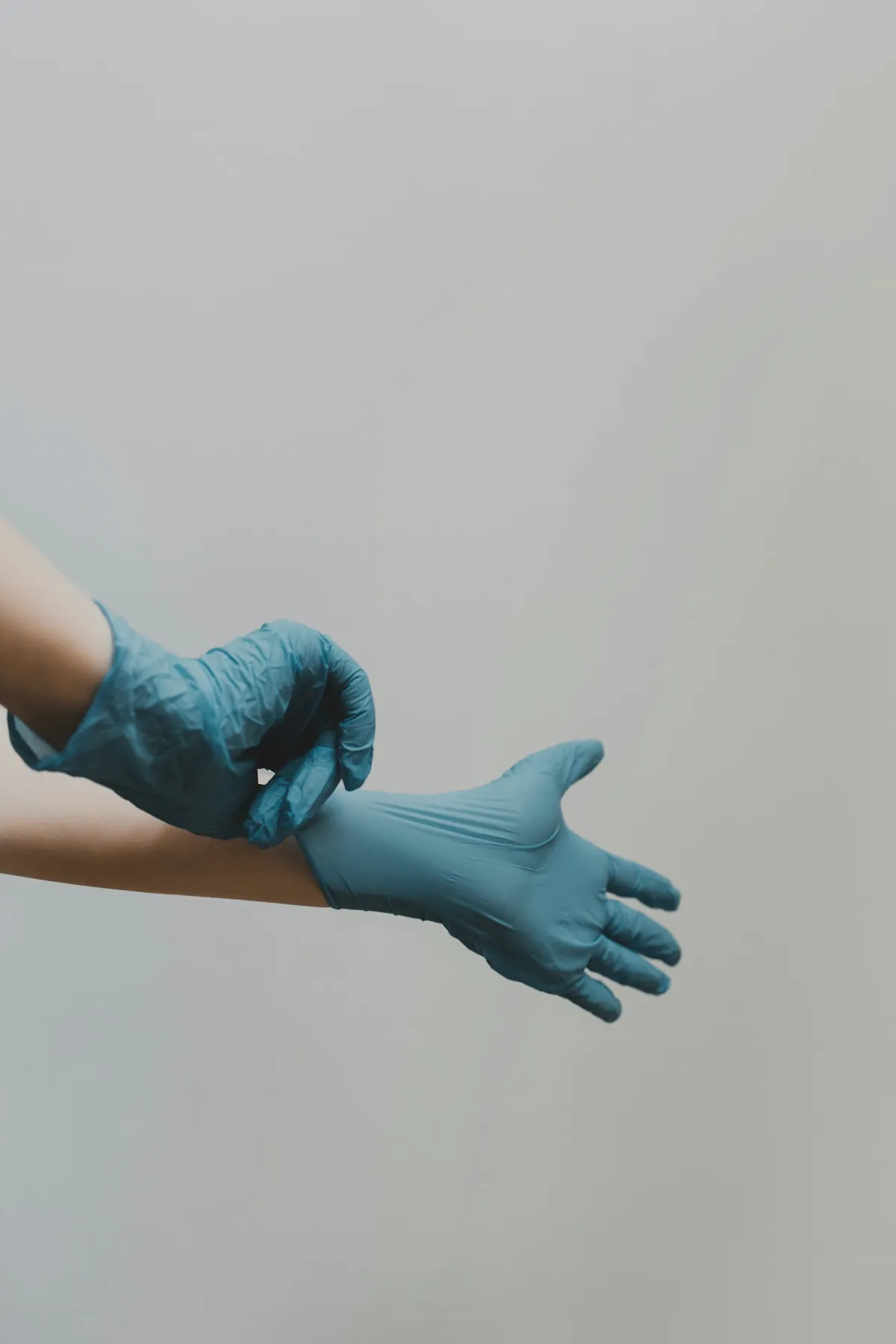 Manos con guantes quirúrgicos azules, imagen de marketing para cirujanos plásticos en Tijuana